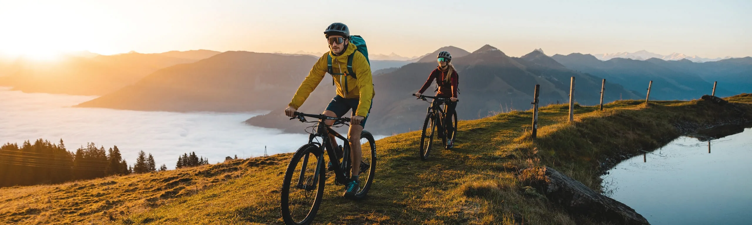 Zwei Radfahrer auf einem Wanderweg in Brixental bei Sonnenuntergang