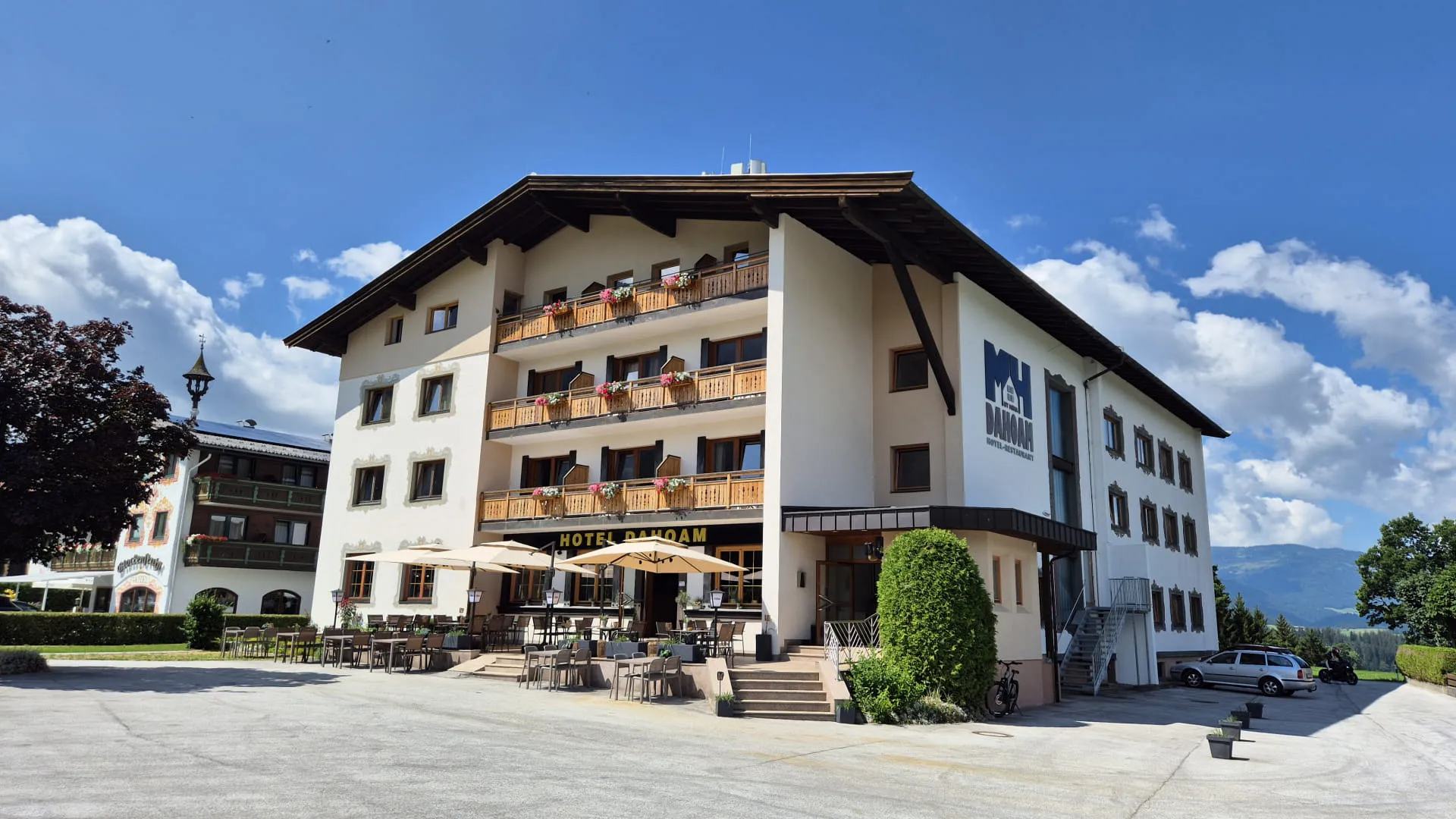 Sommeransicht eines Hauses mit Balkonen und Terrasse