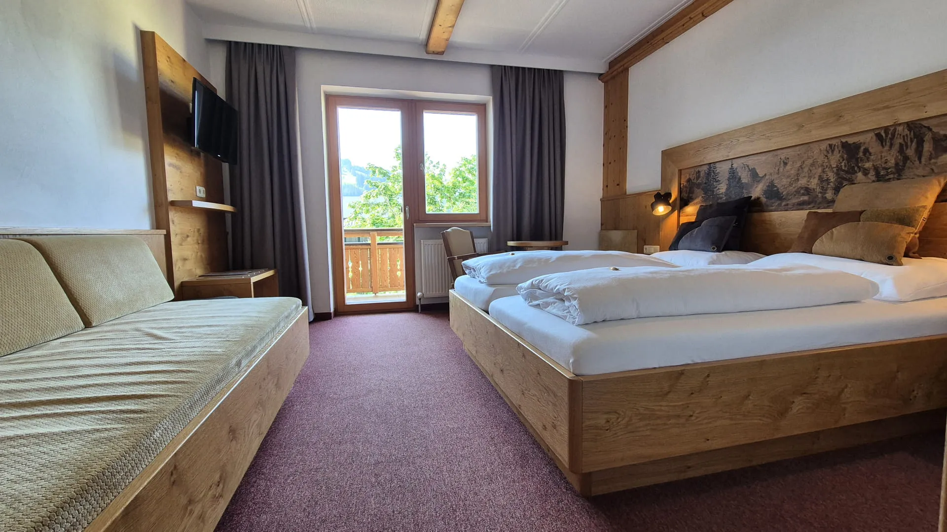 Zimmeransicht mit Fenster, Bett und Sitzecke